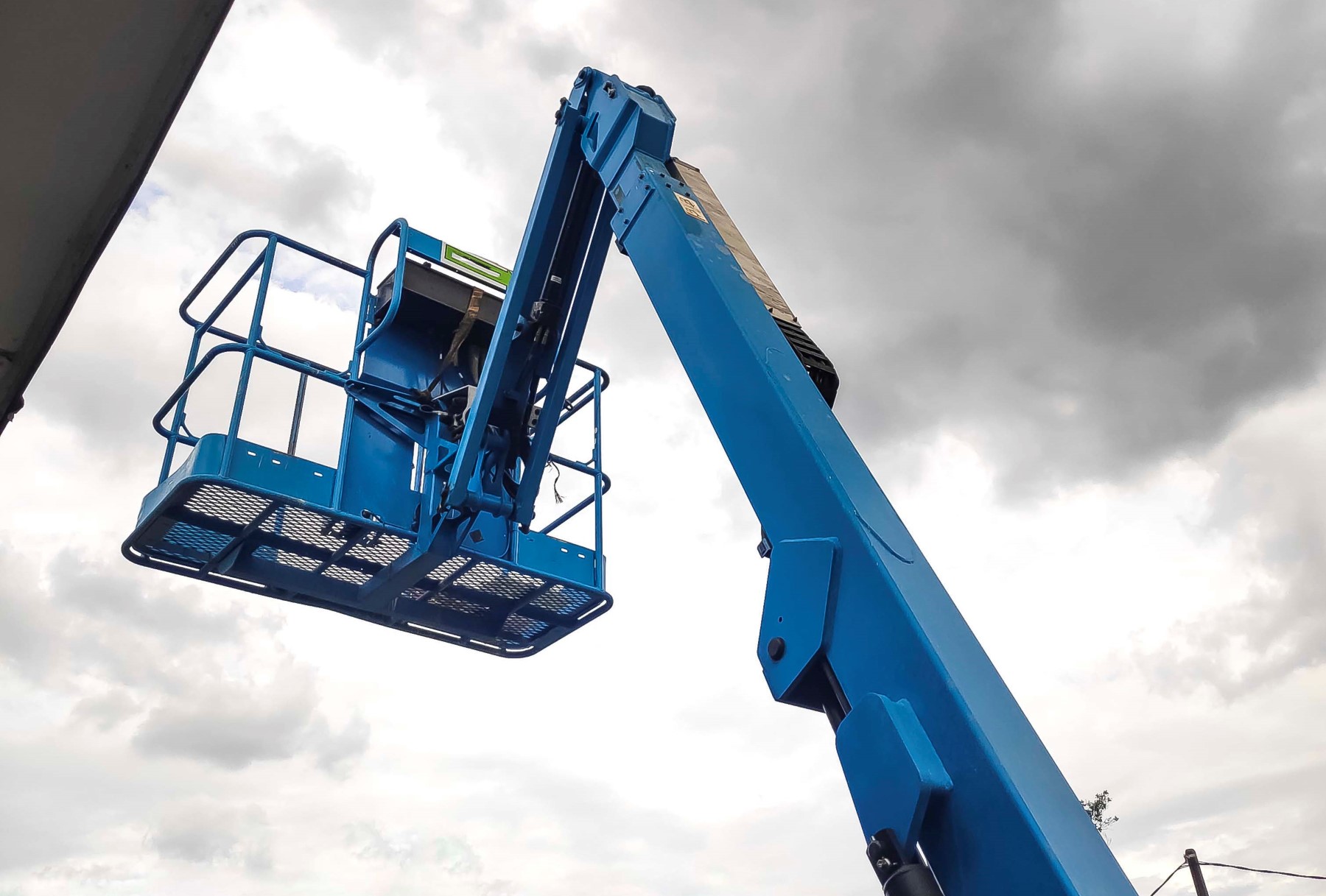 Manlift crane with platform lifting to the roof top of a building